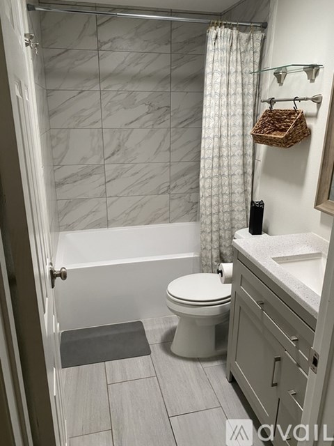 A bathroom with a toilet, sink, and shower.