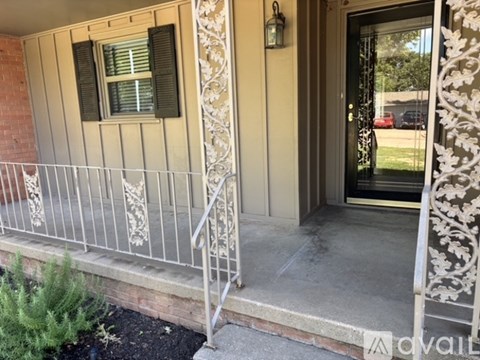 A house entrance with a metal railing and a door.