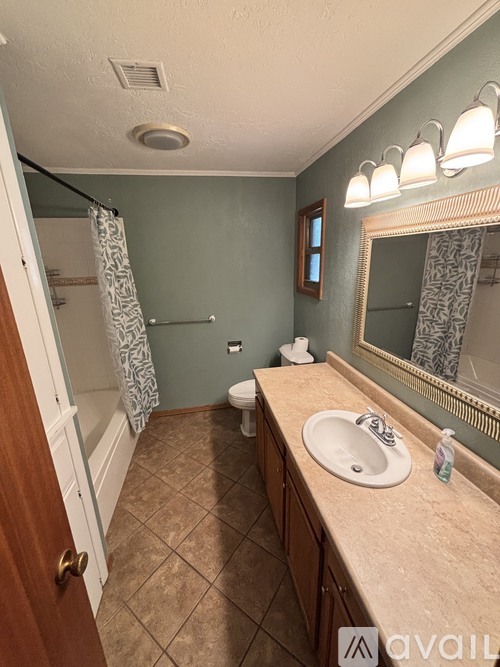 A bathroom with a toilet, sink, and mirror.