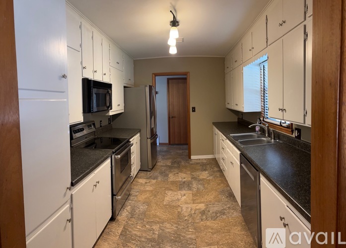 A kitchen with white cabinets and a tiled floor.