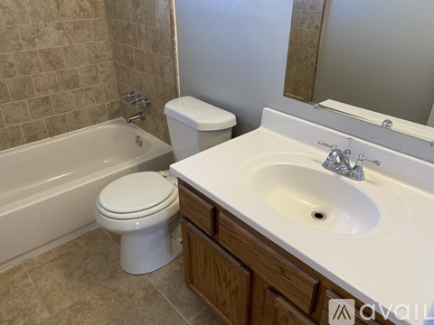 A white toilet sits next to a bathtub in a bathroom.