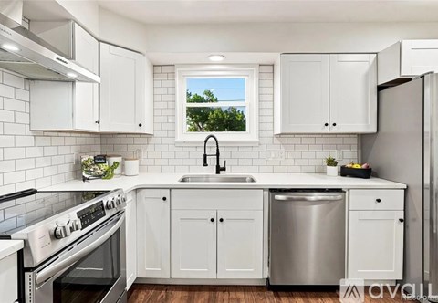 A kitchen with white cabinets and a stainless steel dishwasher.