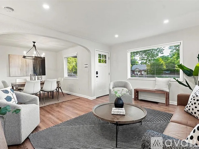 A living room with a white couch, a coffee table, and a rug.