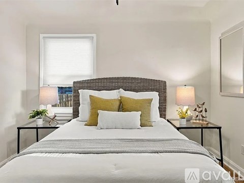 A bedroom with a large bed and two nightstands with lamps.