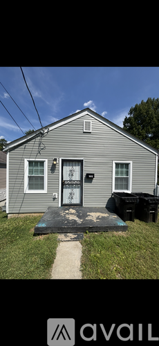 A grey house with a black door and a small porch.