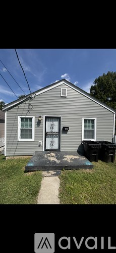 A grey house with a black door and a small porch.