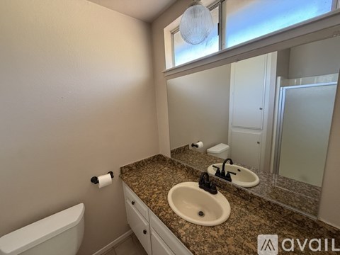 A bathroom with granite countertops and a large mirror.