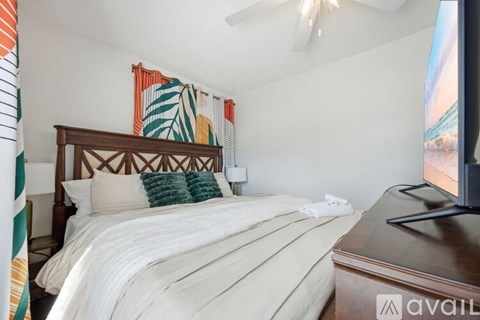 A bedroom with a large bed and a TV on the side.