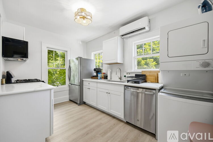 A kitchen with white cabinets and a stainless steel refrigerator.