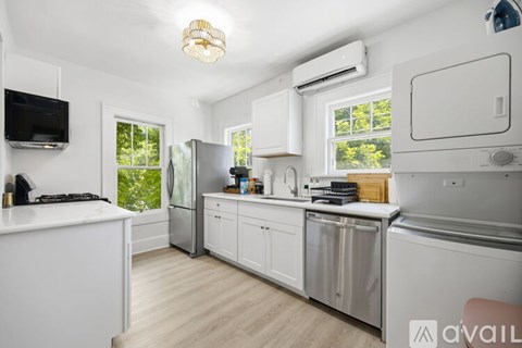 A kitchen with white cabinets and a stainless steel refrigerator.