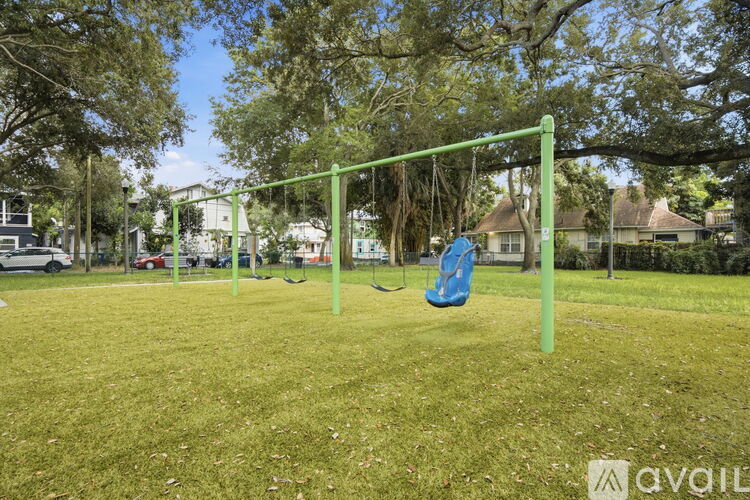 A playground with a green swing set and a blue slide.