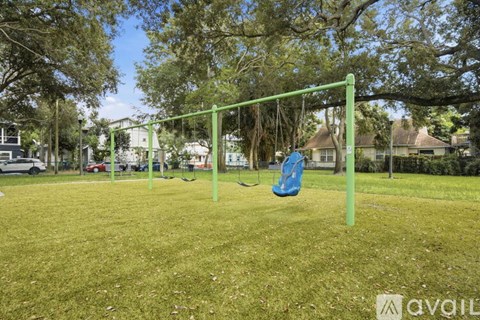 A playground with a green swing set and a blue slide.