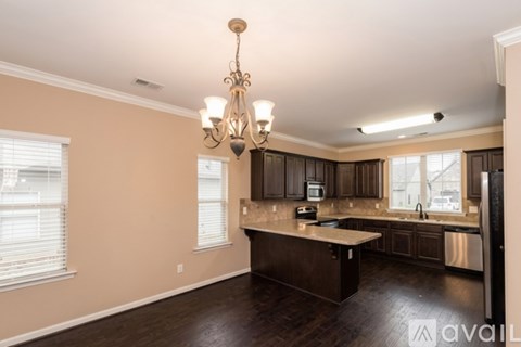 A kitchen with brown cabinets and a chandelier.