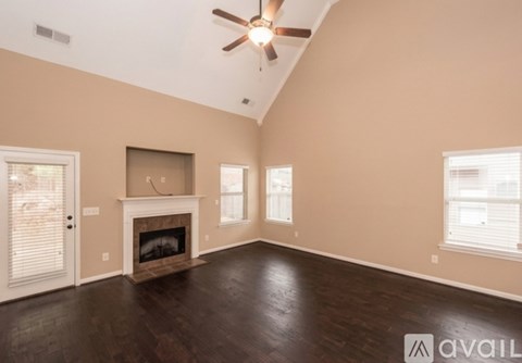 A living room with a fireplace and a ceiling fan.
