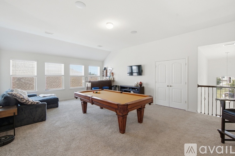A room with a pool table and a couch.