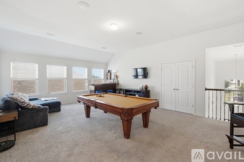 A room with a pool table and a couch.