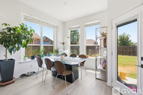 A dining room with a table and chairs.