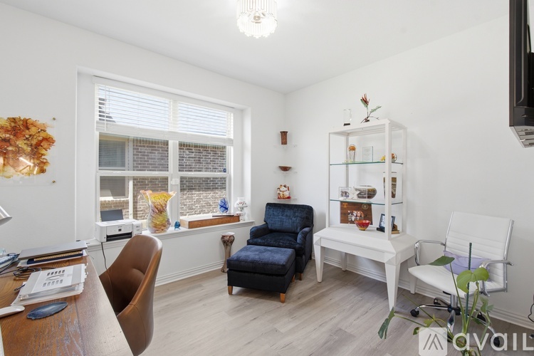 A living room with a blue chair and a white chair.