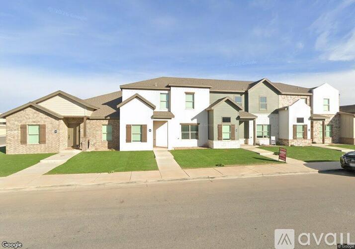 A row of houses with a car parked in front of the first one.