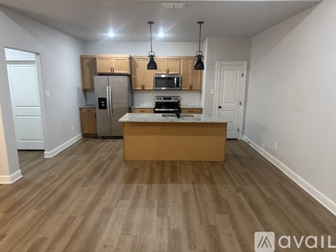 A kitchen with wooden floors and white walls.
