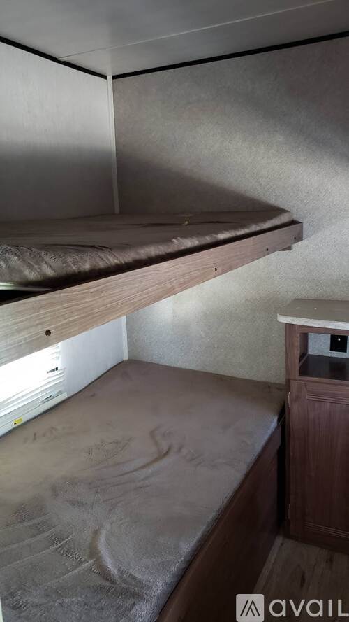 A small bedroom with a bed and a wooden cabinet.