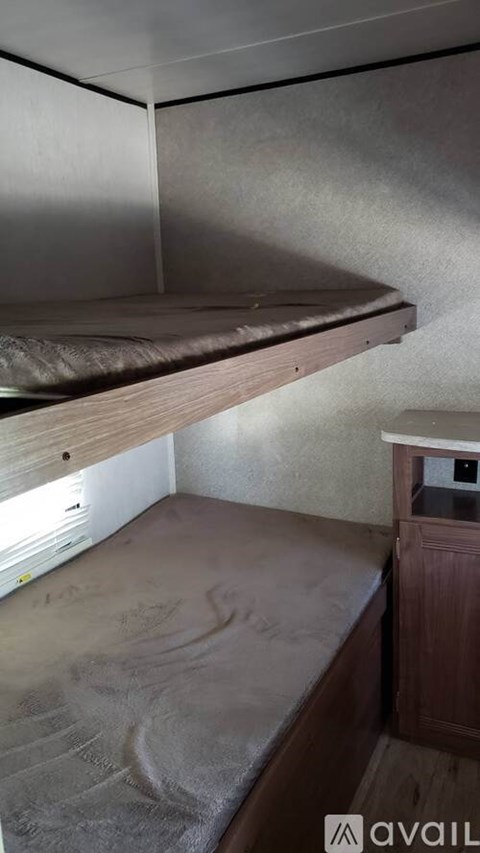 A small bedroom with a bed and a wooden cabinet.
