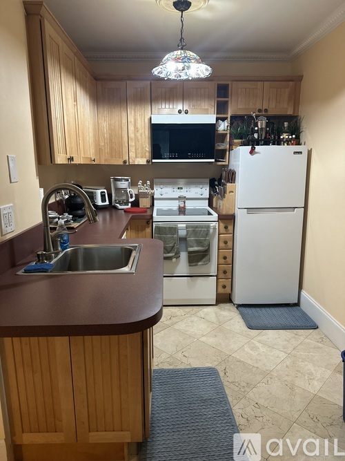 A kitchen with wooden cabinets and a white refrigerator.