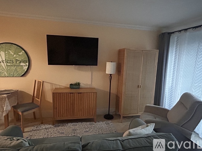 A small, empty room with a window covered by a sheer curtain.