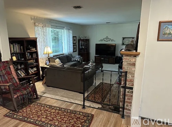 A living room with a couch, chair, and fireplace.