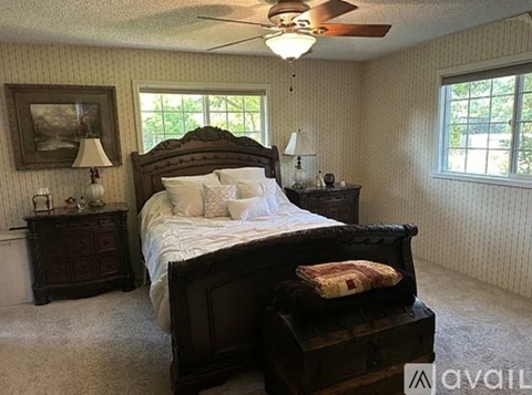 A bedroom with a large bed and a ceiling fan.