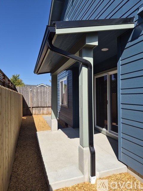 A modern house with a blue exterior and a covered walkway.