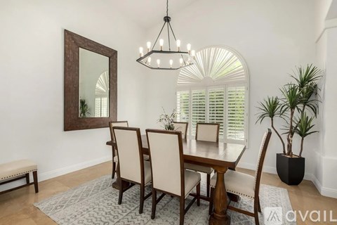 A dining room with a wooden table and chairs.
