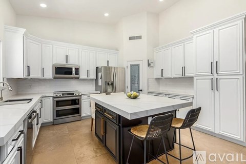 A kitchen with white cabinets and a central island.