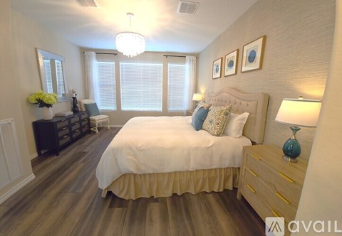 A bedroom with a large bed and a chandelier.