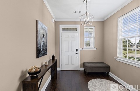 A hallway with a bench, a door, and a painting on the wall.