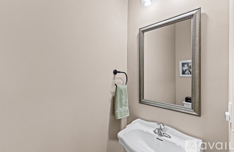 A bathroom with a sink, mirror and towel.
