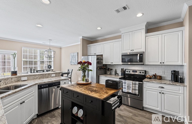 A kitchen with a black stove top oven and white cabinets.