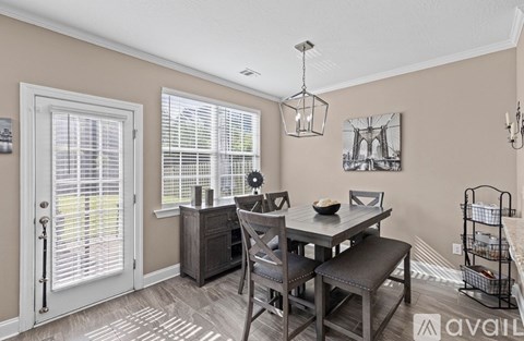 A dining room with a table and chairs.