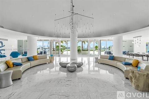 A spacious living room with a large circular stone table at the center.