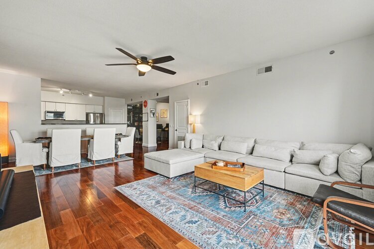 A living room with a white couch and a wooden coffee table.