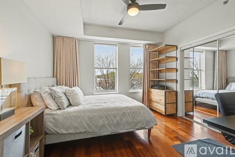 A bedroom with a large bed and a ceiling fan.
