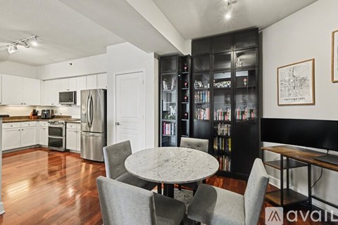A kitchen with a table and chairs in front of a bookshelf.