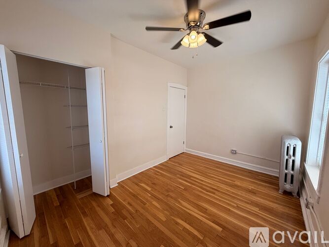 A room with a ceiling fan and wooden flooring.