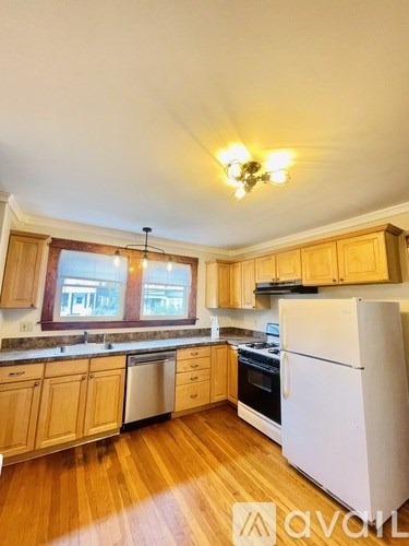 A kitchen with wooden cabinets and a white refrigerator.