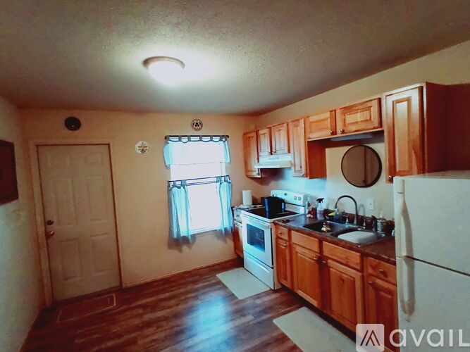 A kitchen with wooden cabinets and a white refrigerator.