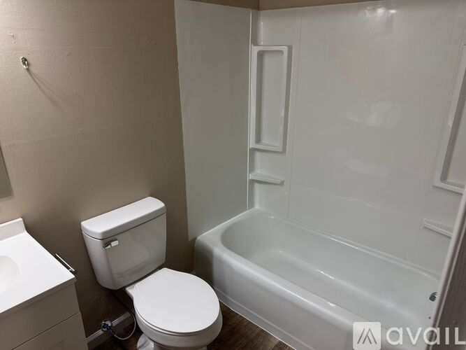 A white toilet sits next to a bathtub in a bathroom.