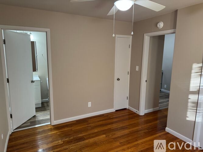 A room with wooden floors and a ceiling fan.