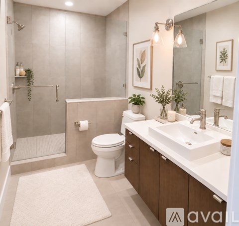 A bathroom with a white toilet, a white sink, and a glass shower stall.