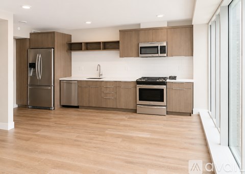 A modern kitchen with wooden cabinets and stainless steel appliances.