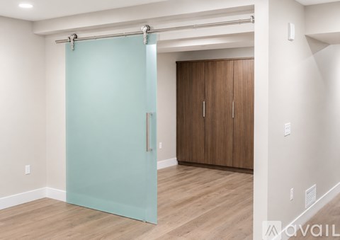 A room with a sliding door and wooden flooring.